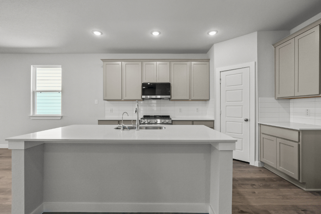 A kitchen with white cabinets.