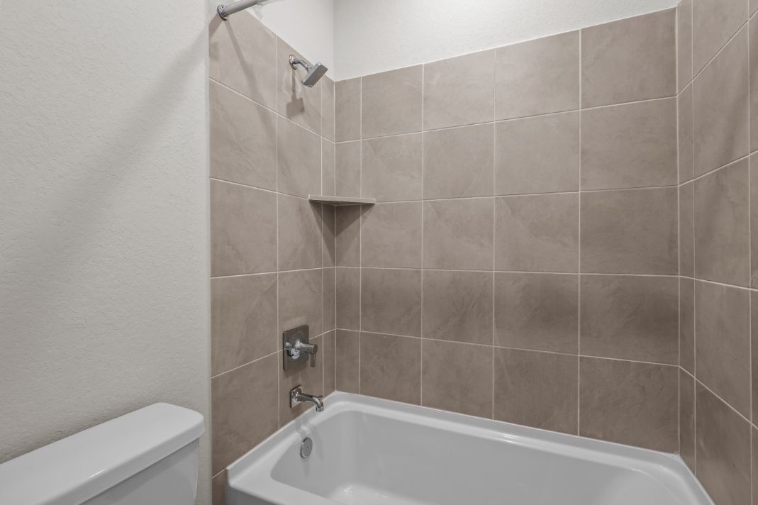 A bathroom with a bathtub and toilet.