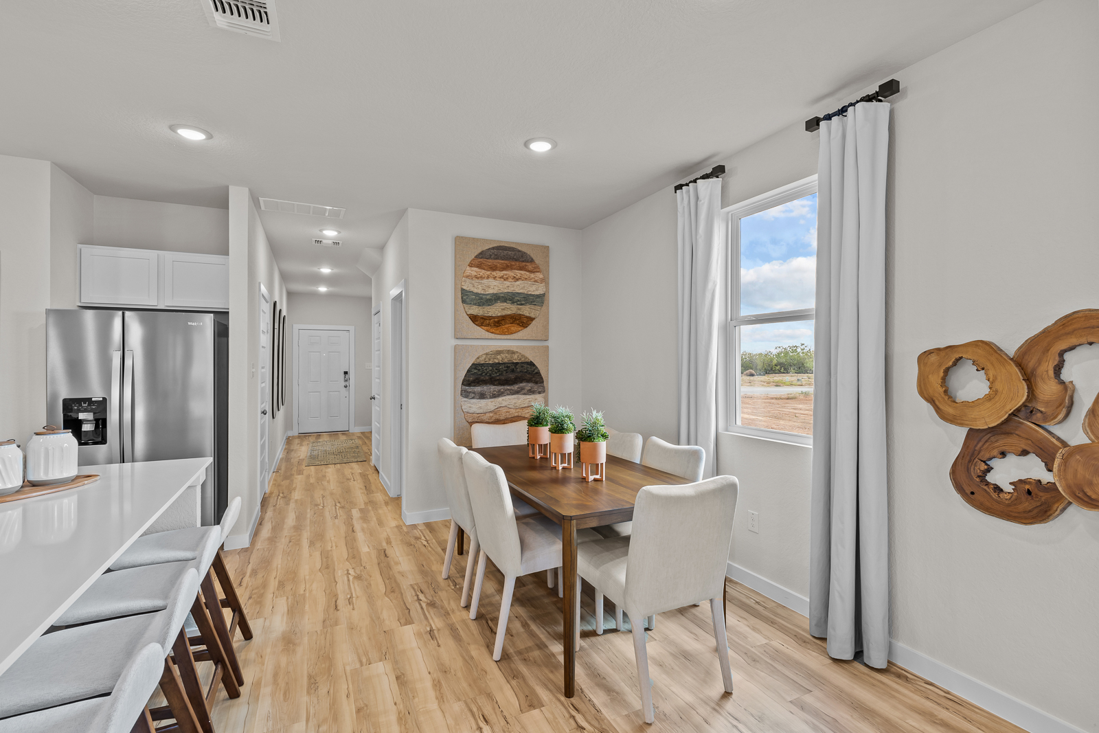 A kitchen with a dining table and chairs.
