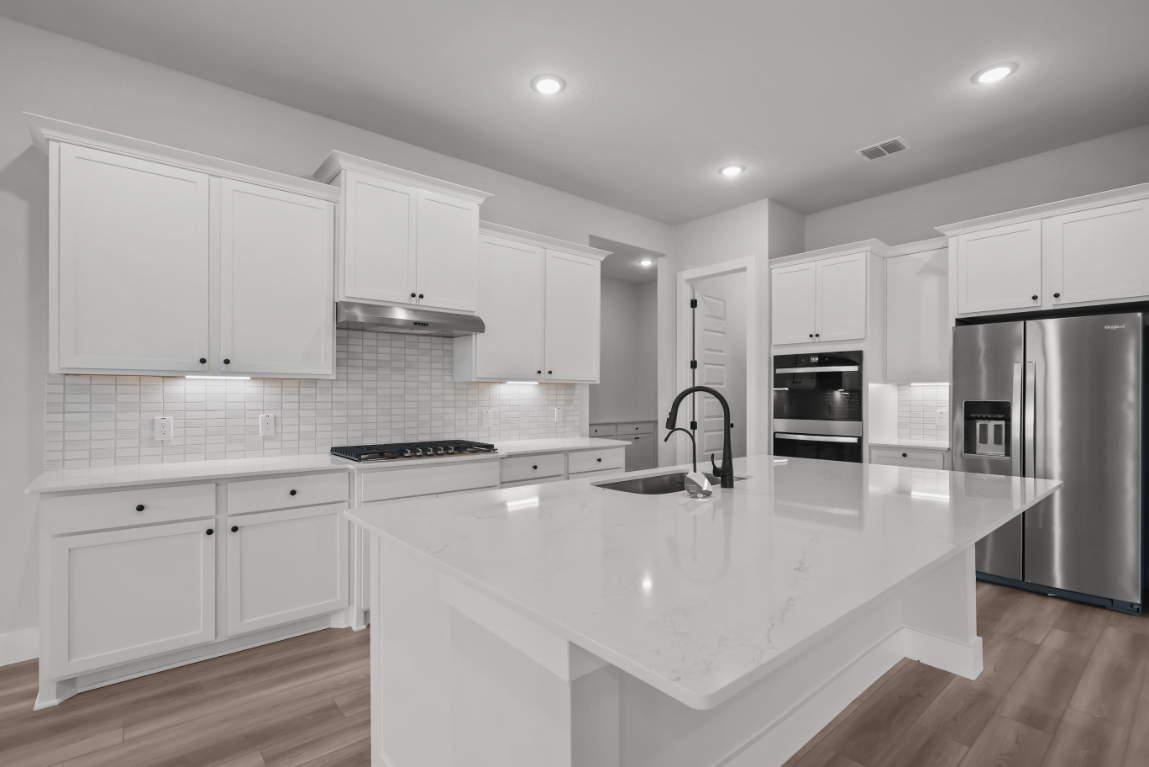 A kitchen with white cabinets.