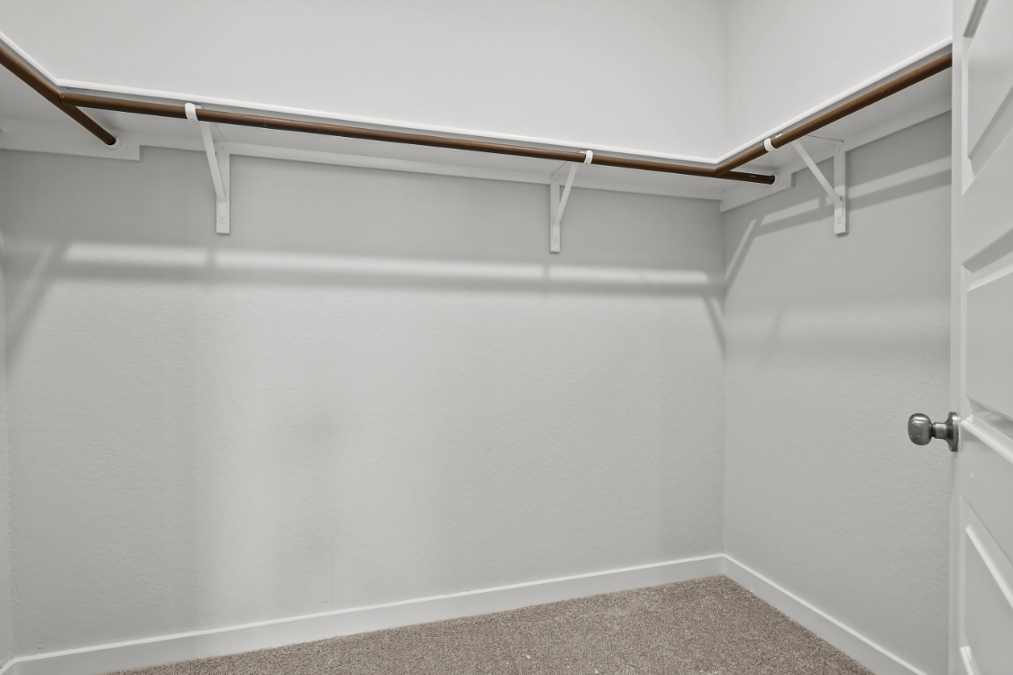 A white wall with a metal bar.