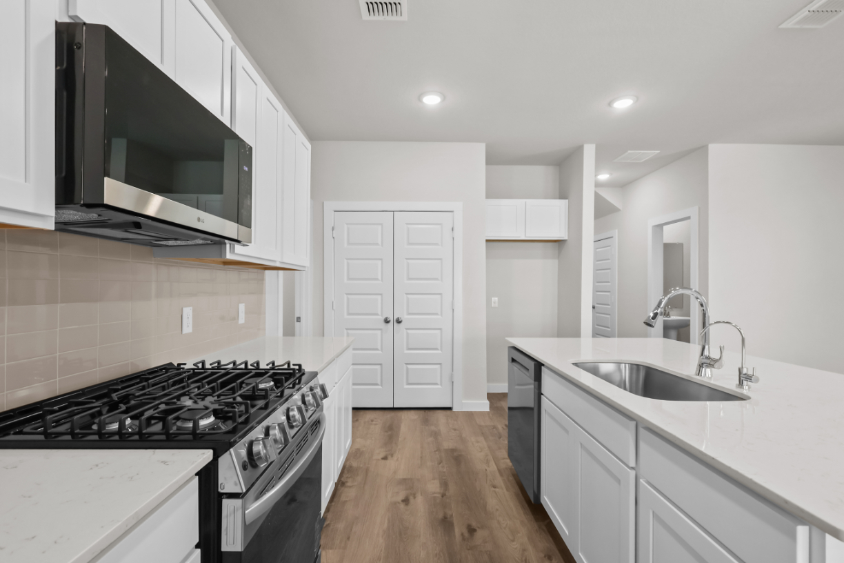 A kitchen with white cabinets.
