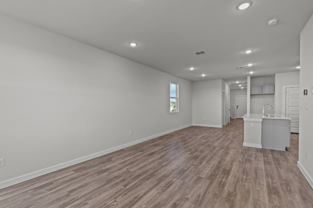 A room with white walls and wood floors.