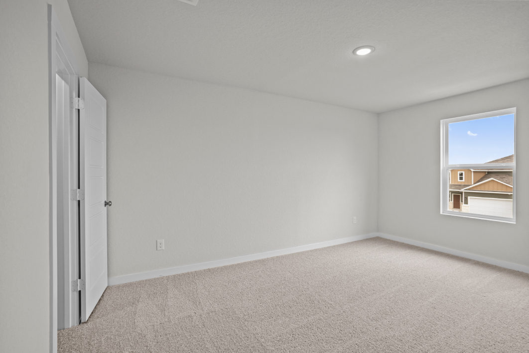 A room with a window and a carpet.