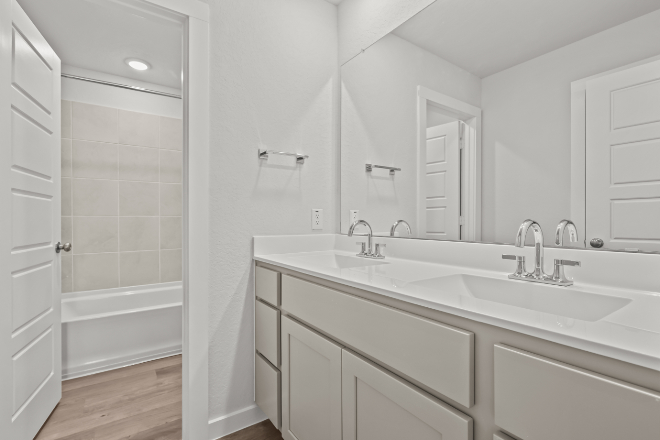 A bathroom with a sink and a mirror.