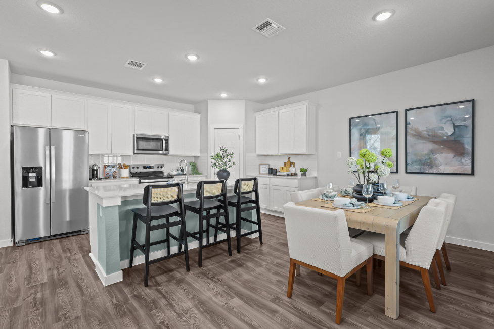 A kitchen with a dining table and chairs.