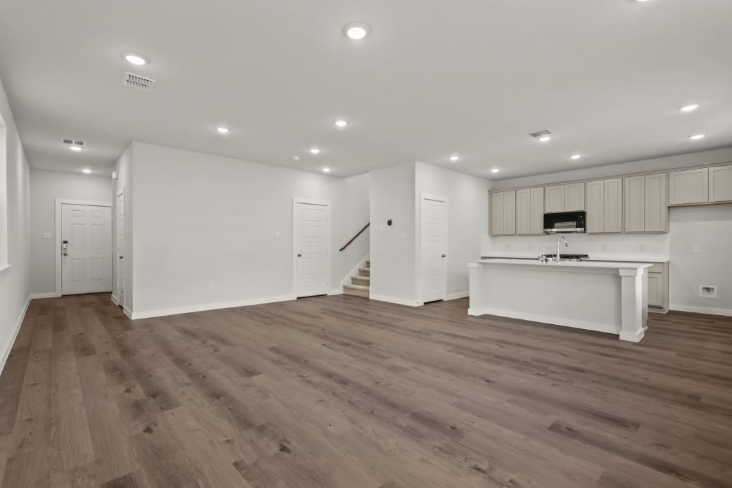A large empty room with white cabinets.
