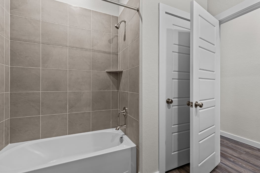 A bathroom with a bathtub and shower.