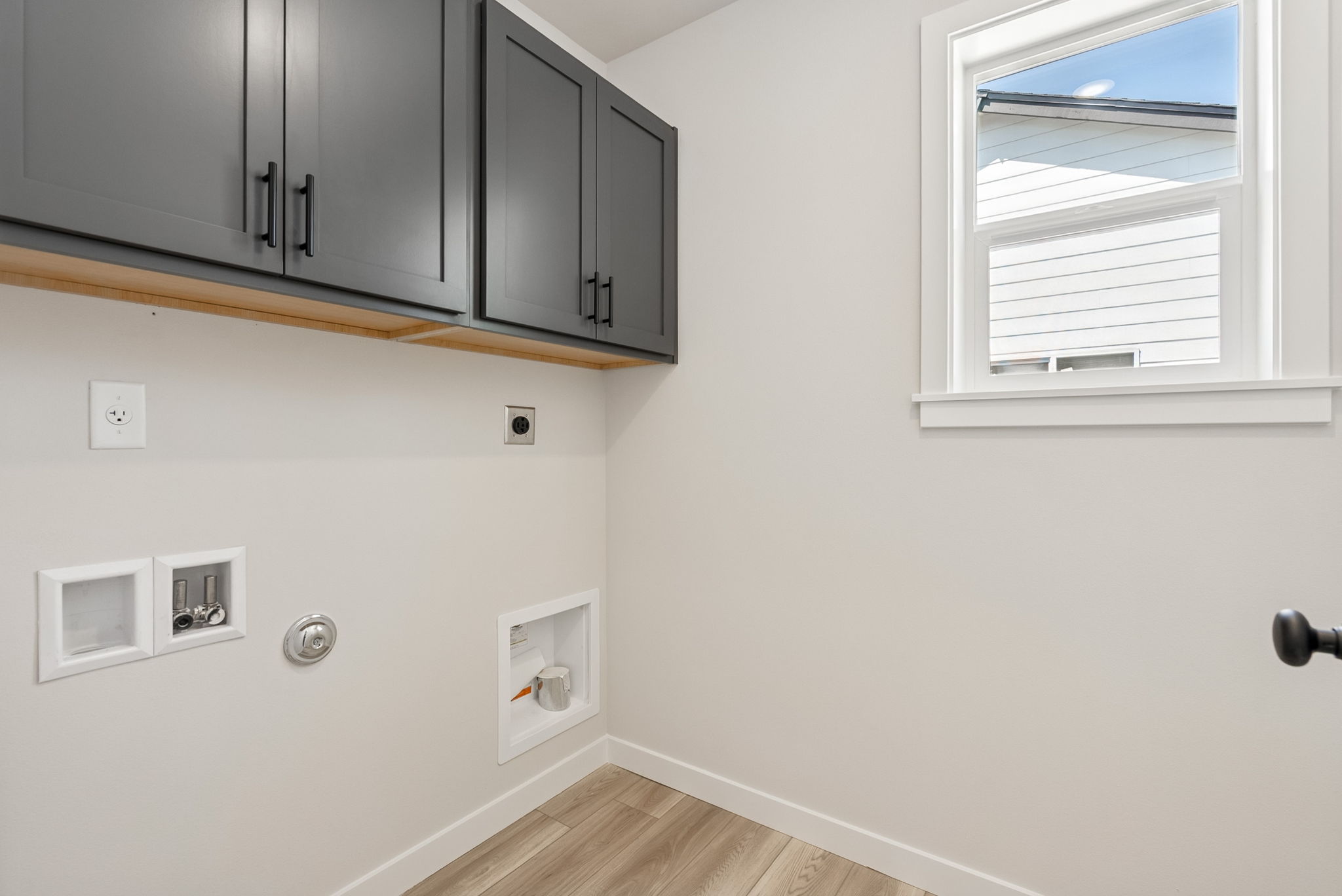 A room with white walls and black cabinets.