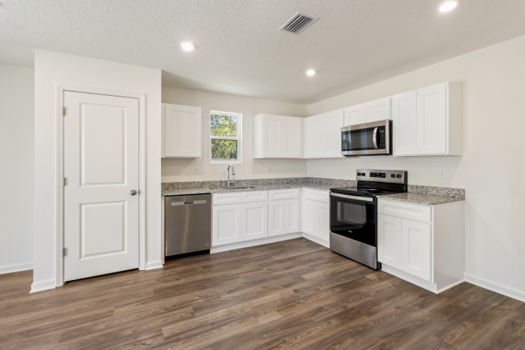 A kitchen with white cabinets.