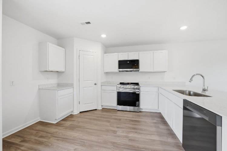 A kitchen with white cabinets.