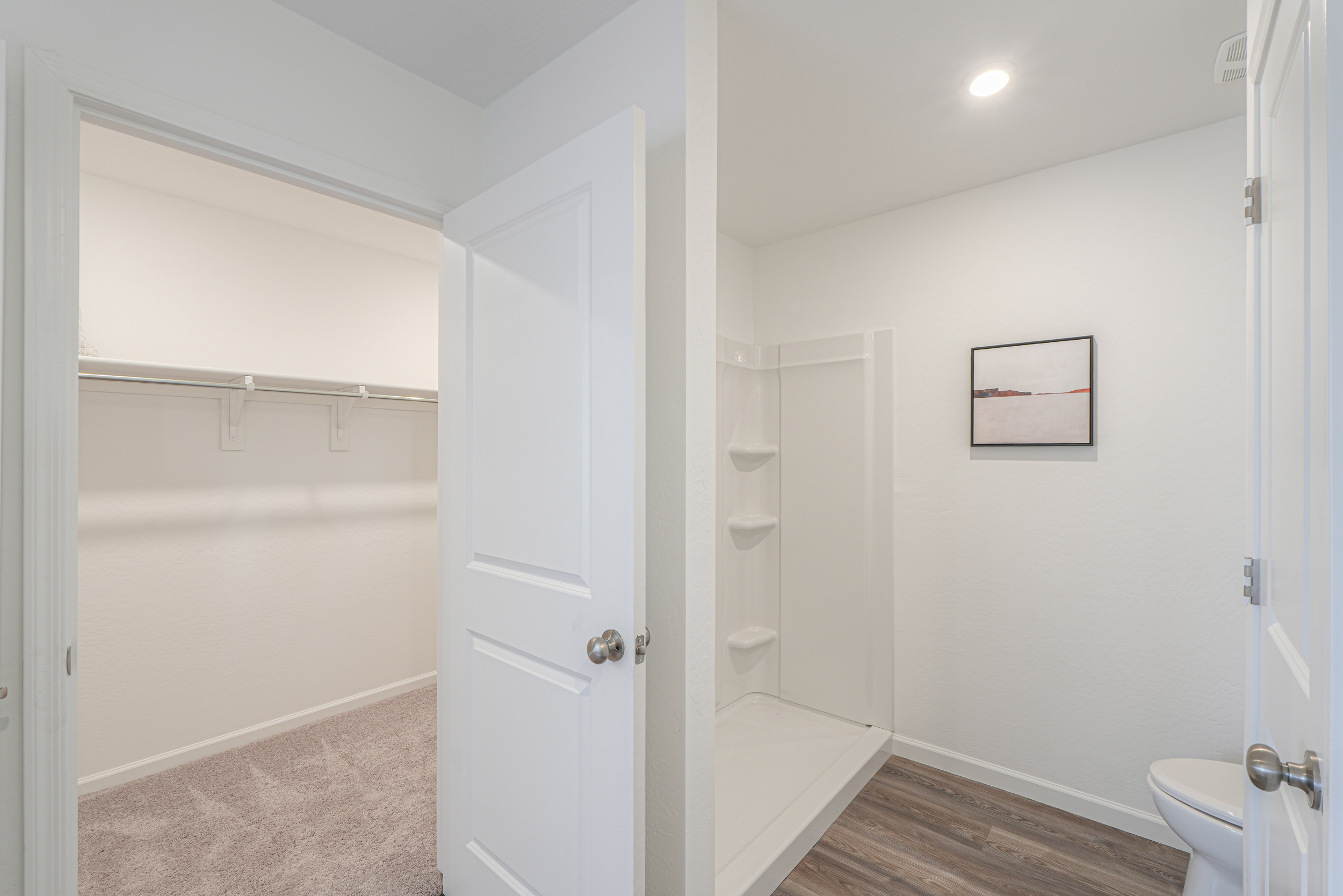 A bathroom with a shower unit and toilet.