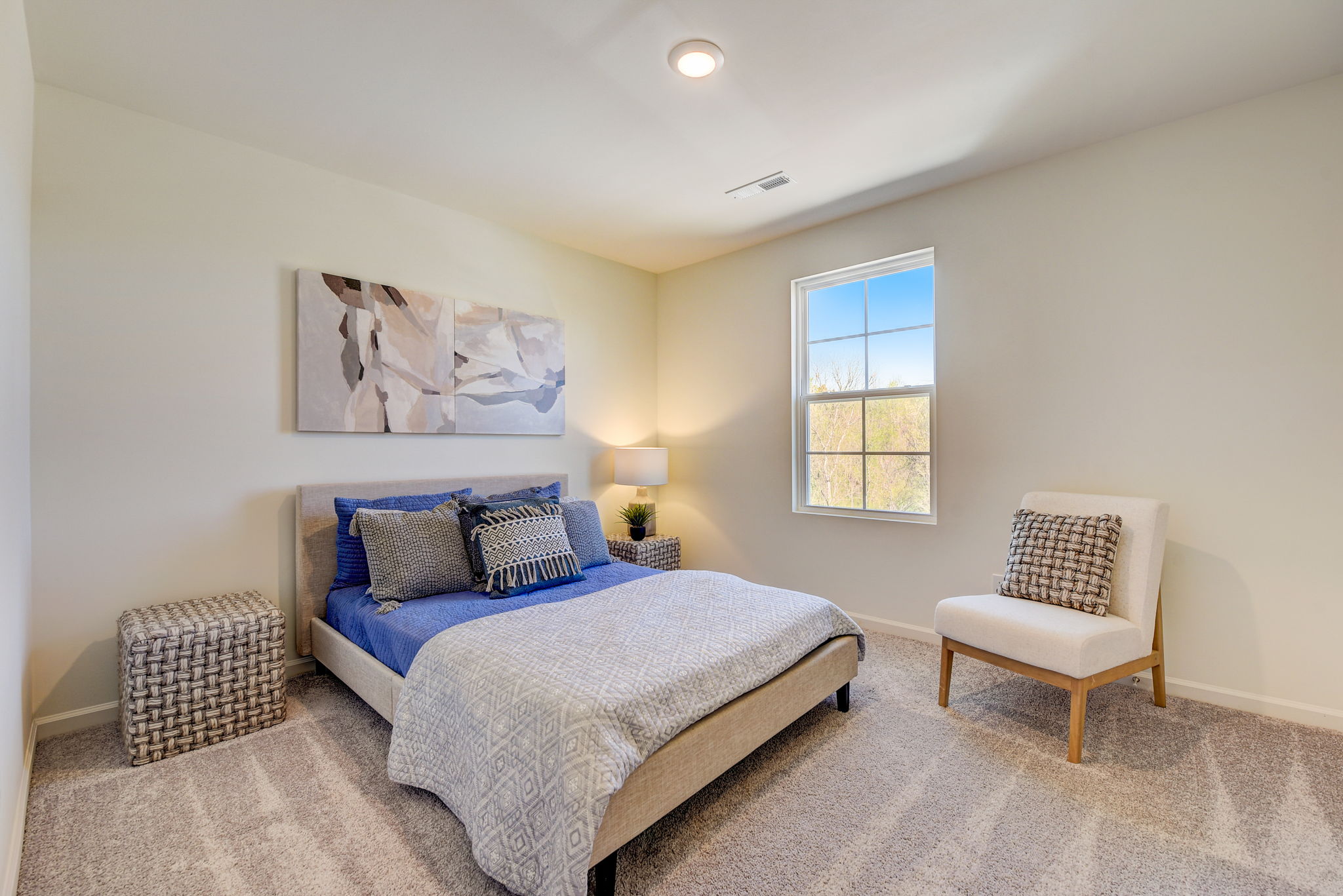 A bedroom with a bed and a chair.