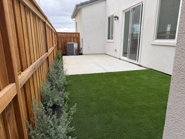 A backyard with a fence and a house.